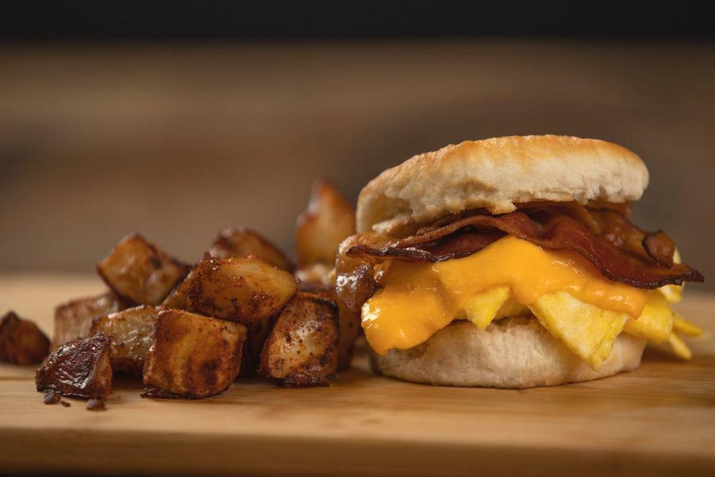 Bacon (Or Sausage) Egg & Cheese Biscuit · Your choice of bacon or a sausage patty, egg, and American cheese on a grilled biscuit. Served with a choice of home fries or chips.