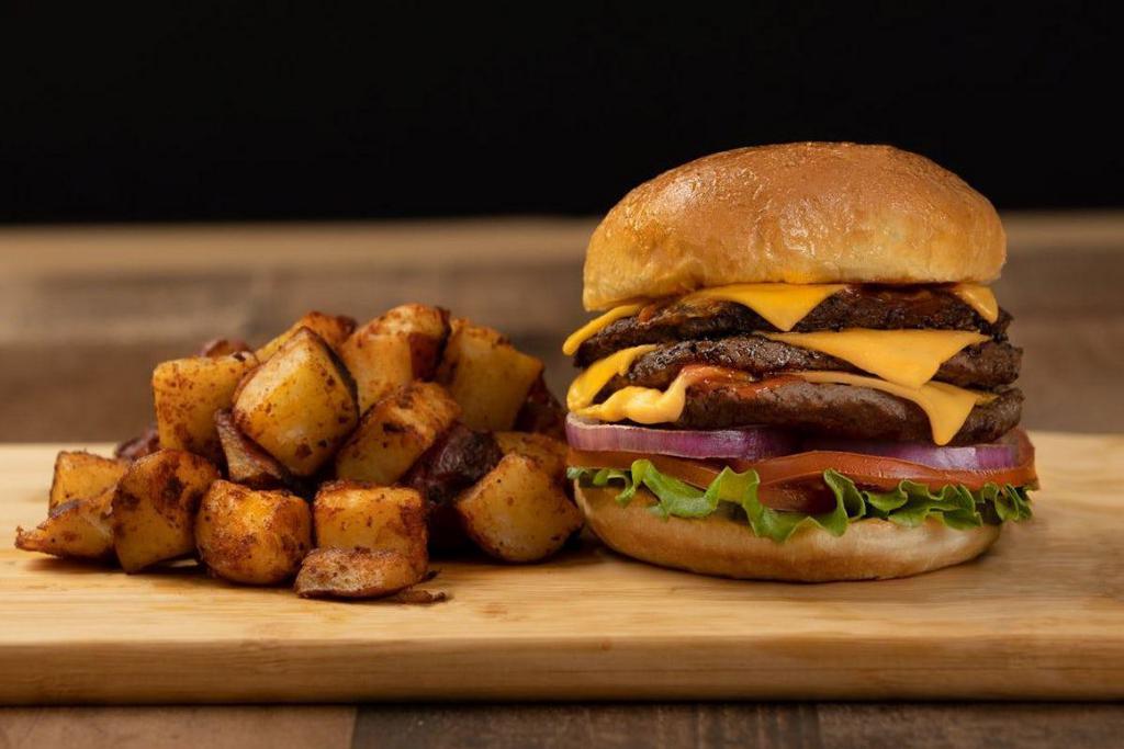 Triple Stack Bacon Cheeseburger · Three juicy, steak burger patties stacked with American cheese, red onion, lettuce, tomato, mustard, ketchup, and pickles on a grilled brioche bun served with a choice of home fries or chips.