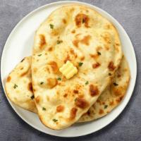 Butter Naan · Freshly baked bread in a clay oven garnished with butter