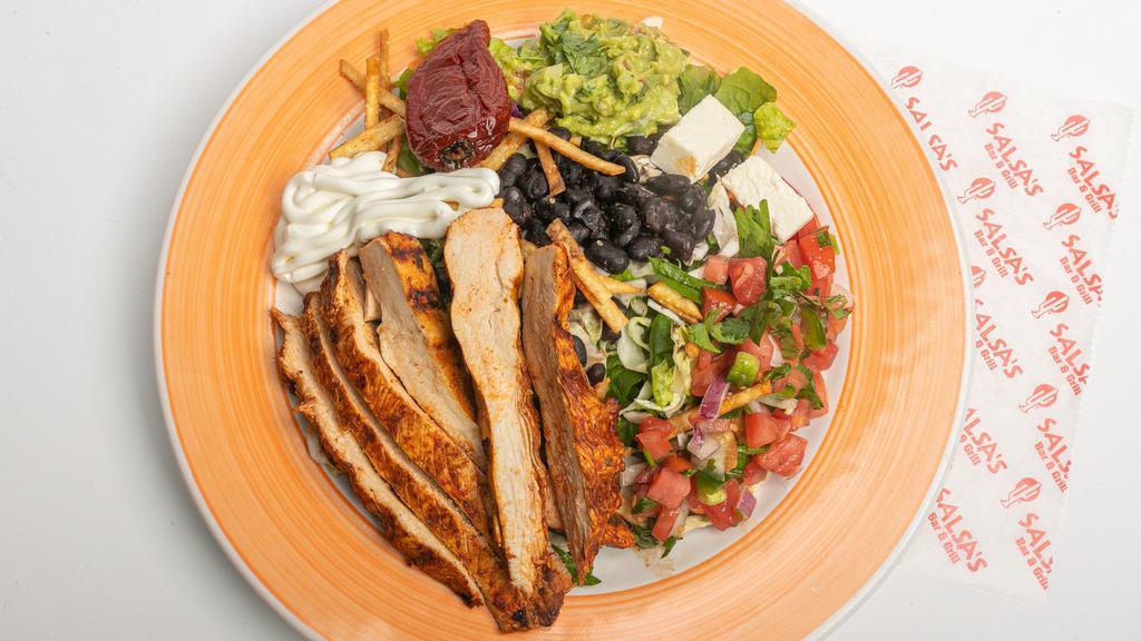 Santa Fe Chicken Salad · Grilled chicken, served on a bed of lettuce, topped with black beans, pico de gallo, crispy tortilla chips, and queso fresco, served with guacamole, and sour cream.