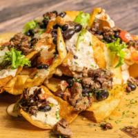 Nachos · Tortilla chips served with house made cheese sauce, black beans, sour cream, and pico de gal...