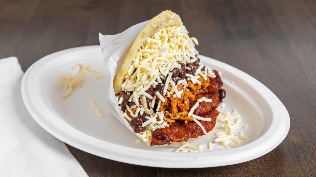 Pabellon Arepa · Arepa filled with black beans. shredded beef, sweet plantain and grated white cheese / Arepa rellena con frijoles, carne mechada, platano maduro y queso blanco rallado