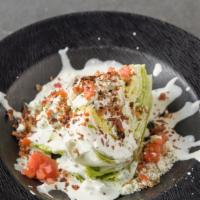 Baby Wedgie · Iceberg wedge with blue cheese dressing, blue cheese crumbles, bacon, tomatoes, and a drizzl...