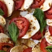 Caprese · Fresh mozzarella, sliced tomatoes, pesto, spring mix lettuce