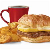 Sausage, Egg & Swiss Croissant Combo · A fresh-cracked grade A egg and grilled sausage covered in creamy swiss cheese sauce on a fl...