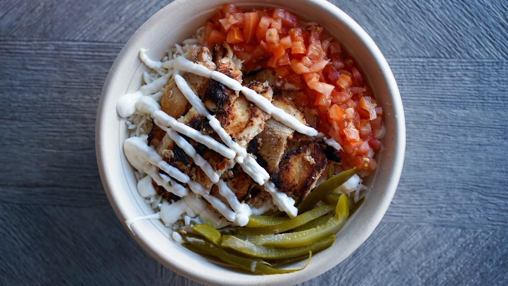 Chicken Shawarma Over Rice · Chicken shawarma over basmati rice. Served with pickles and garlic sauce.