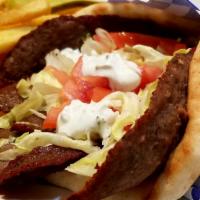 Lamb Gyro · Greek-style seasoned lamb cooked on a spit wrapped in a pita with lettuce, tomato, and a sid...