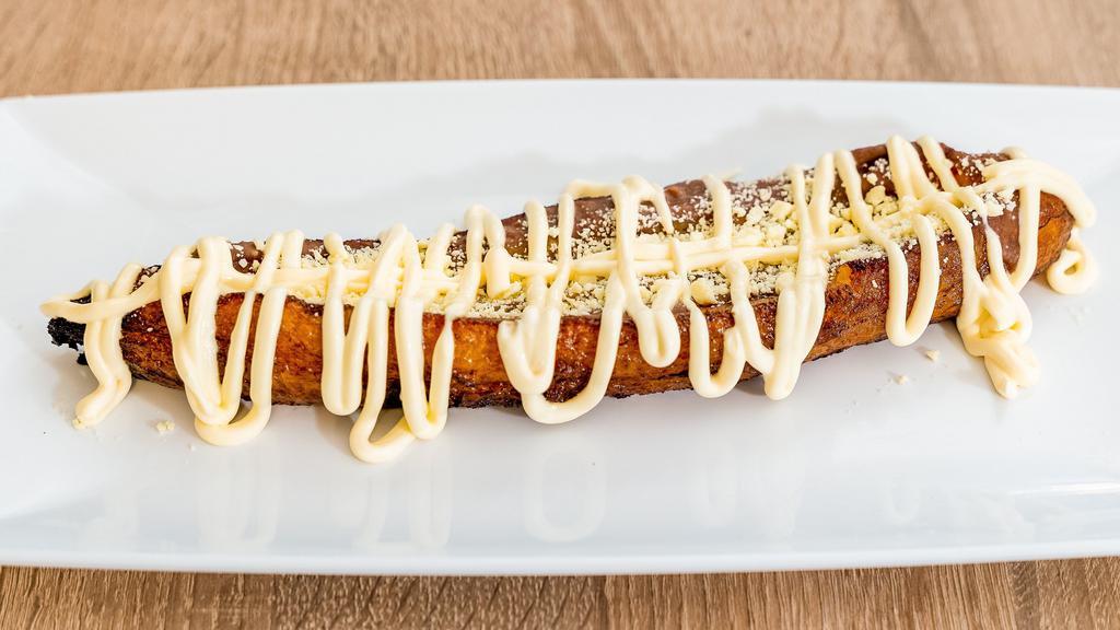 La Canoa · Platano entero relleno con frijoles Fritos, crema y queso. Whole Fried Plantain filled with refried beans, homestyle sour cream and fresh cheese.