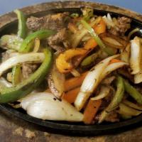 Fajitas De Carne/Steak Fajitas · Cooked with onions, green and red bell peppers.