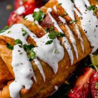 Chimichanga · Deep fried to golden crisp. This one is a beast! Fried chicken or angus beef topped with che...