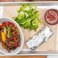 Family Meal - Brisket Fajitas · smoked pulled brisket with peppers and onions plus flour tortillas.  lettuce and salsa on th...