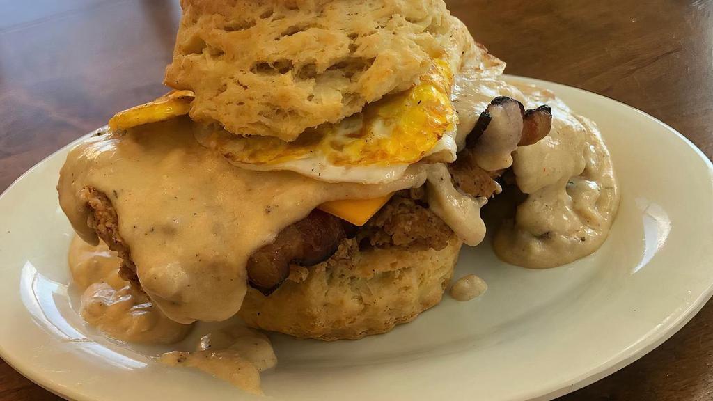The Cowboy · Our flaky biscuit with country fried steak, pecanwood bacon and a fried egg, topped with cheddar cheese & sausage gravy