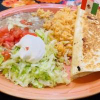 Tradicional Quesadilla · A flour tortilla filled with cheese and your choice of ground beef or shredded chicken. Serv...