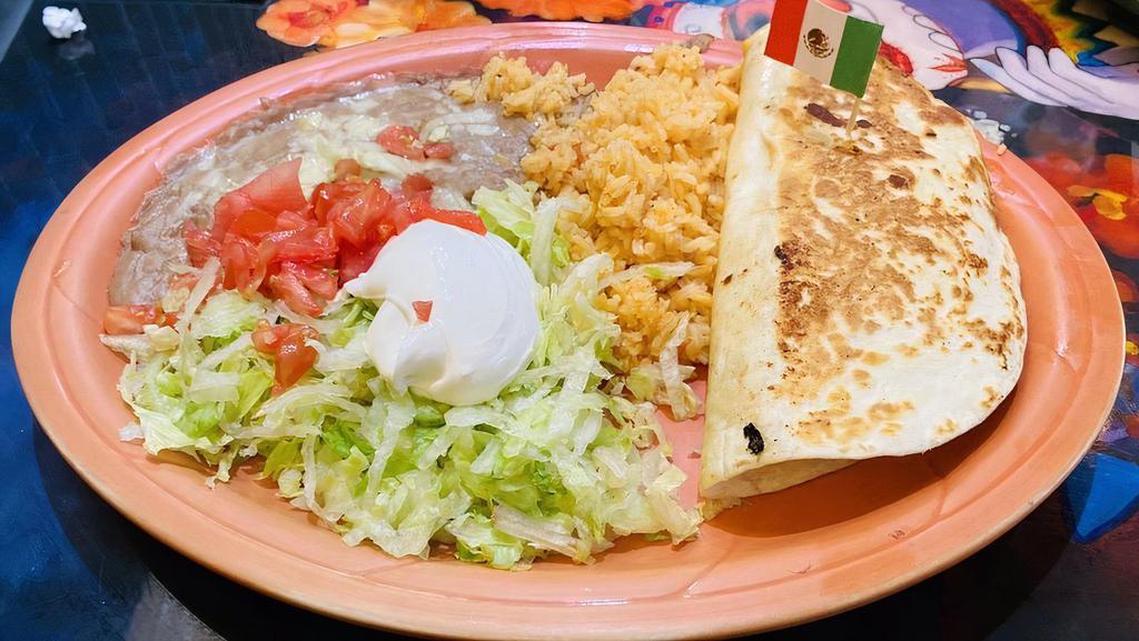 Tradicional Quesadilla · A flour tortilla filled with cheese and your choice of ground beef or shredded chicken. Served with lettuce, diced tomatoes, sour cream, rice, and beans.