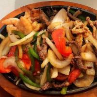 Texas Fajitas · A loaded platter of grilled steak, chicken breast, and shrimp.