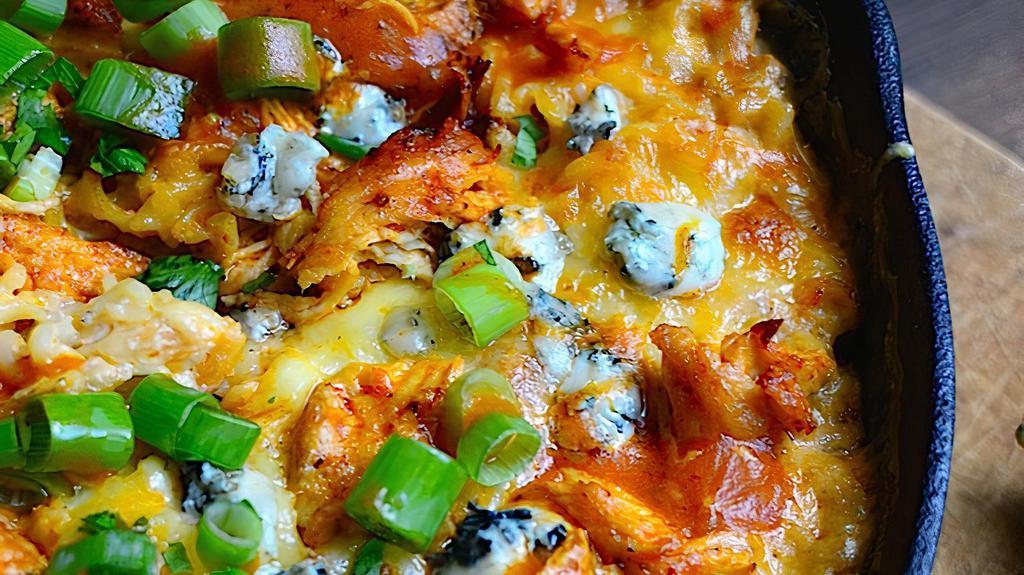 Buffalo Mac And Cheese · Baked Mac and cheese topped with crispy chicken, Buffalo sauce, ranch sauce, scallions and blue cheese crumbles.