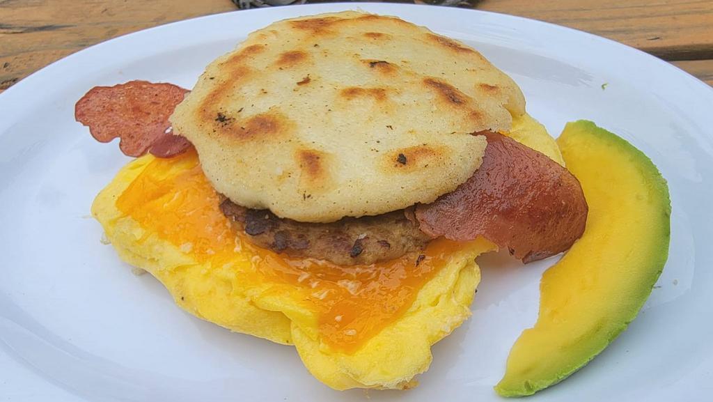 Big Breakfast Arepa · 2 fresh cracked cage-free scrambled eggs, melted Cheddar cheese, bacon, breakfast sausage, grilled onions and Sriracha aioli in a fried arepa
