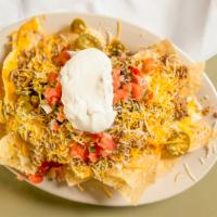 Nachos · Tortilla chips smothered in a combination of cheddar, nacho and queso blanco cheese, black b...