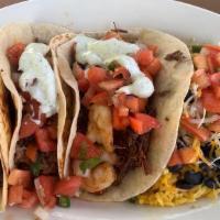 Fried Chicken Tacos · Crispy chicken topped with sautéed onions, tomatoes and spicy mayo. Served with rice and bea...