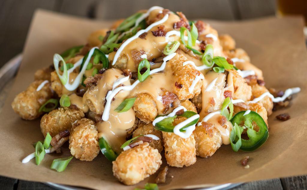 Loaded Taters · Beer - Infused. Tater tots loaded with our amber ale beer cheese & topped with fresh jalapeños, applewood smoked bacon, scallions & drizzled with sour cream.