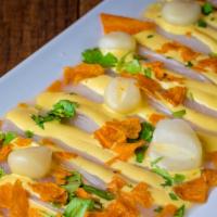 Tiradito Ceviche · White fish marinated, sweet potato chips, cilantro, Peruvian corn, served with huancaina or ...