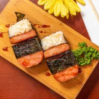 Spam Musubi · Bedded on sushi rice with roasted black seaweed, pan fried sliced span with sweet sauce.