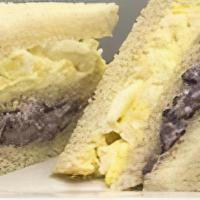 Triple De Aceituna Sandwich · Peruvian black olives with pecans and raisins. Hard egg with mayonnaise in white bread.
