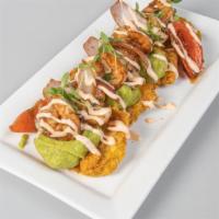 Fried Green Plantains With Shrimp And Guasacaca · Wok-smoked shrimp on a bed of fried green plantains, pink sauce, and guasacaca.