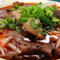 Spicy Lemongrass Beef Soup · Lemongrass beef broth with rice vermicelli noodle topped with blood cubed, pork ham, beef sh...