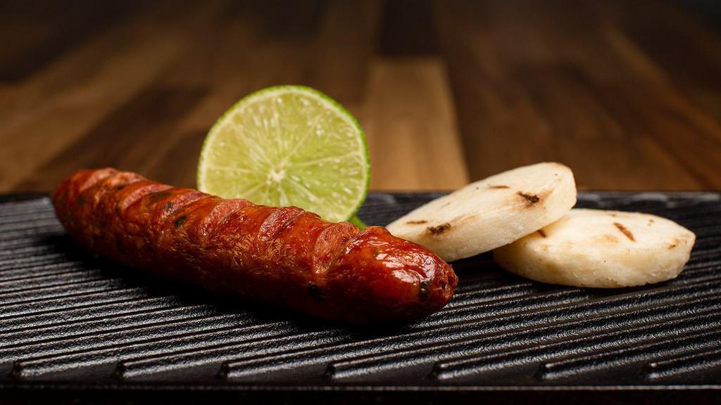 Chorizo · Imported Colombian chorizo with arepita and lime wedges