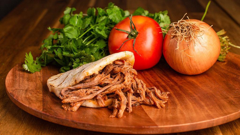 Arepa Con Carne Desmechada · Arepa stuffed with deliciously shredded beef with Colombian Guizo!