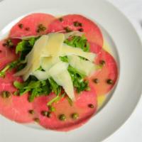 Beef Carpaccio · Thinly Sliced Beef Carpaccio, Capers, Basil and Shaved Parmesan Cheese.