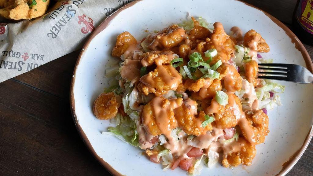 Fire Shrimp · Tender, crispy shrimp tossed in a creamy spicy sauce and served over a bed of fresh greens.