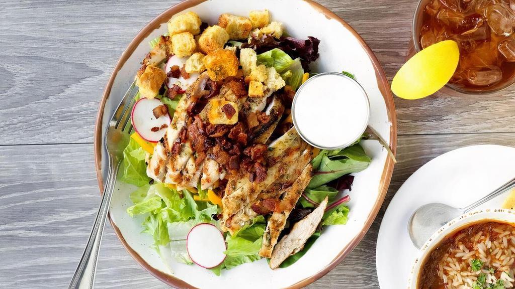 Steamer House Salad · Fresh mixed greens topped with cherry tomatoes, cucumbers, cheddar cheese, bacon, house made croutons, and sliced radish. Option to top with chicken or shrimp.