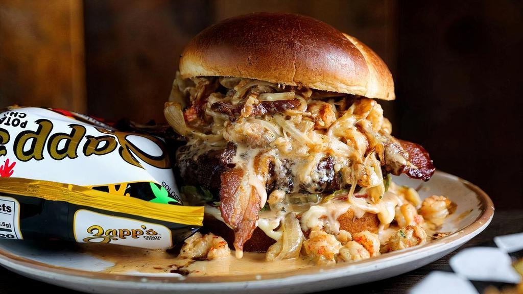 Voodoo Burger · ½ lb brisket burger with Tabasco bacon, cheddar, and pickles smothered with caramelized onions, crawfish tails and our signature Voodoo Cream Sauce. Served with fries or Zapp's Voodoo chips.