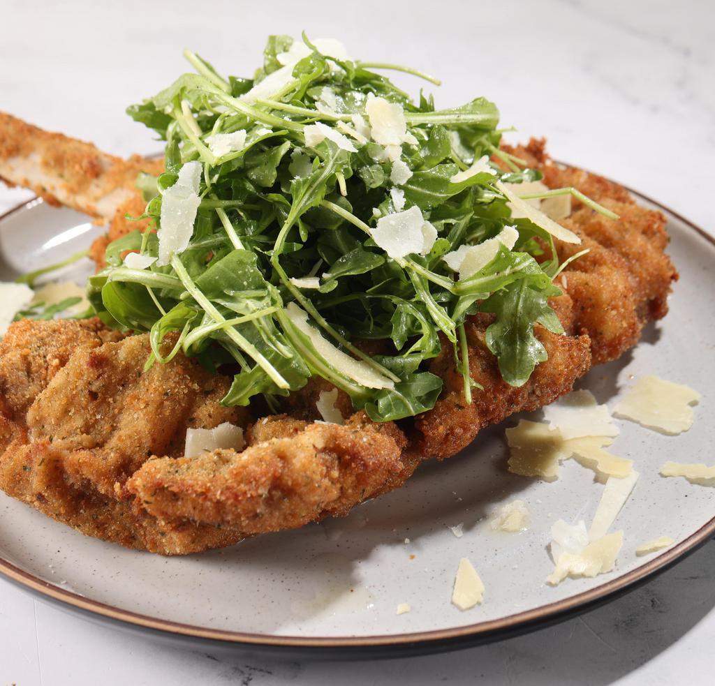 Orecchia D'Elefante (Veal) Original Milanese · Butterflied bone-in veal chop Milanese style served on a bed of fresh baby arugula, shaved Parmesan, and citrus vinaigrette.