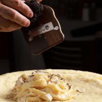 Pasta Alla Forma · Tagliatelle pasta in creamy cheese and black pepper sauce tossed inside the cheese wheel wit...