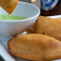 Chicken Fried Empanada · Savory crescent-shaped corn dough fried and filled with chicken.