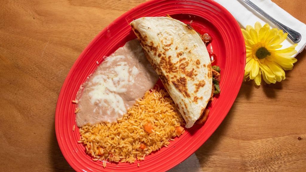Texas Quesadilla · Grilled steak, chicken and shrimp, served with rice, beans, bell peppers and onions.