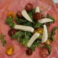 Carpaccio Di Manzo · Marinated Beef Carpaccio served with Shaved Parmesan, Cherry. Tomatoes over a bed of Arugula...