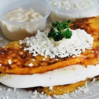 Cachapa · Traditional corn based pancake served with queso de mano inside. Topped with cream and white...
