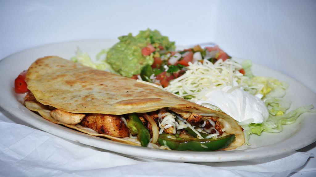 King Quesadilla · 12 inch tortilla folded, grilled, and stuffed with steak or chicken fajitas. Served with a side salad or rice and beans.