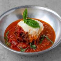 Homemade Meatball · One homemade meatball topped with mozzarella cheese and tomato sauce.