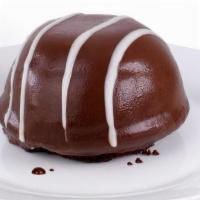 New! Tuxedo Bomb  · A rich chocolate cake base is layered with milk chocolate & white chocolate mousse and cover...