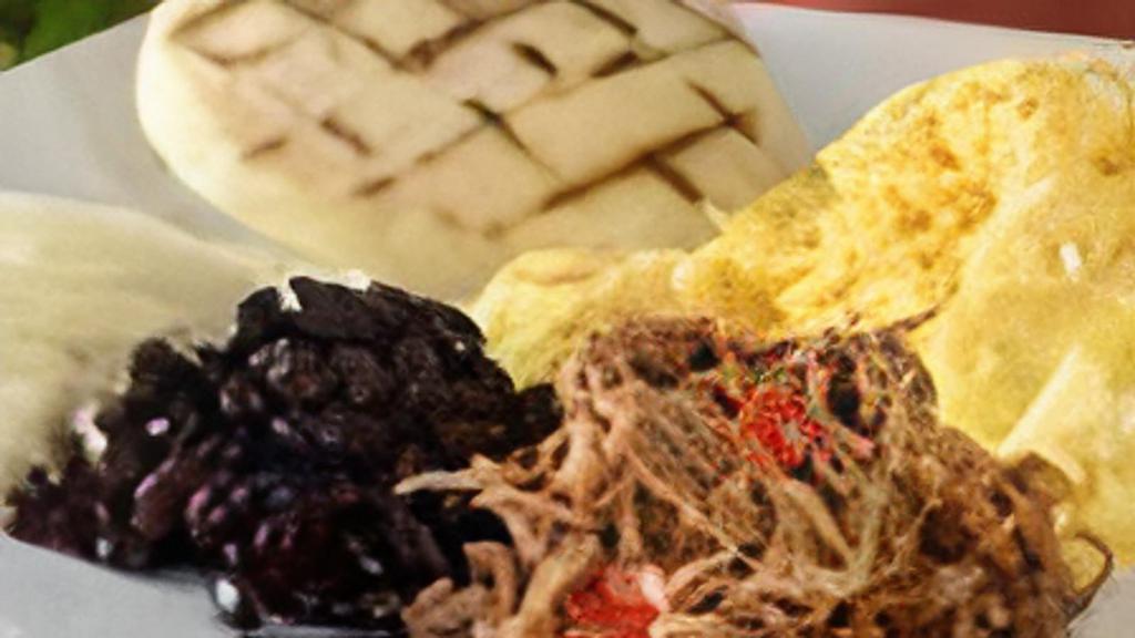 Criollo Breakfast · Two eggs cooked to order, arepa, sweet plantains, shredded beef, black beans and shredded paisa cheese.
