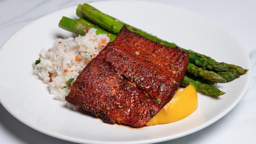 Cajun Oven Roasted Atlantic Salmon* · Blackened salmon with confit garlic butter, spring onion rice and seasonal vegetables.