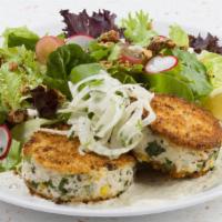Jumbo Lump Crab Cakes + Greens · Two golden panko crusted cakes, poached shrimp, remoulade, house greens salad.