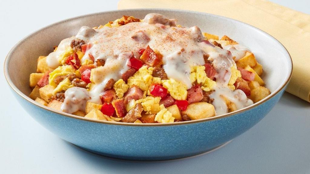 Three Smothered Piggies · Don't decide, have ALL the meats! Seasoned country potatoes, scrambled eggs mixed in with sautéed diced yellow onions and red peppers, chopped bacon, sausage crumbles and diced ham, smothered in country sausage gravy and peppered with paprika.