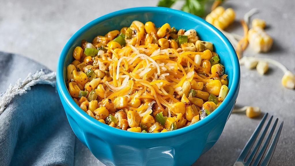 Cheesy Fire Roasted Corn · A great starter or side dish. Juicy fire-roasted corn, mixed with a fresh green herb sauce, melted blended cheese and a smoky southwestern sauce.