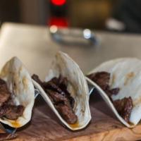 Street Tacos · Three tacos flour or corn tortilla filled with your choice of meat topped with charred onion...